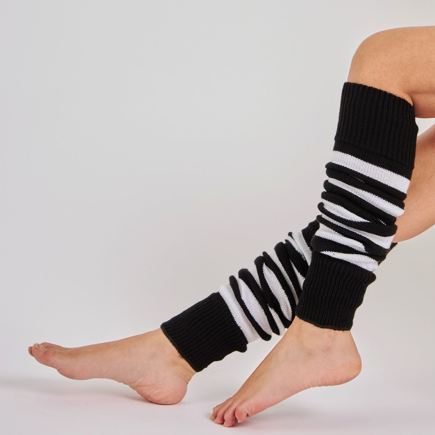 Woman wearing Mysocks black and white striped 100% acrylic leg warmers