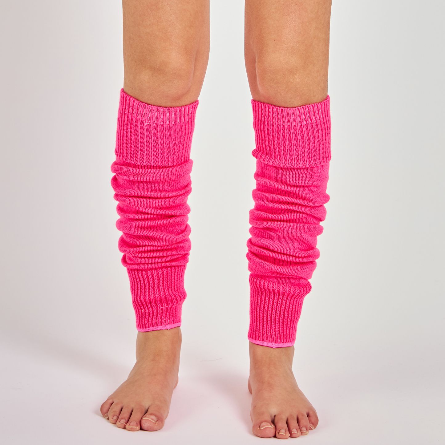Woman's legs wearing neon pink ribbed knit leg warmers for dance and parties